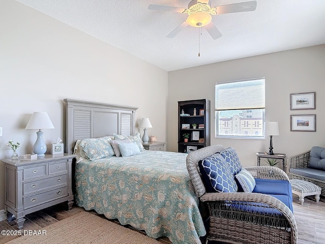 bedroom featuring ceiling fan, a textured ceiling, and wood finished floors