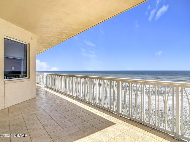 balcony with a beach view and a water view