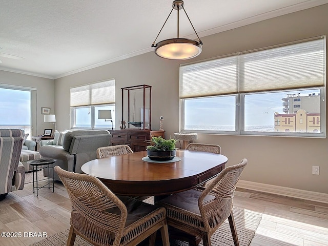 dining space with light wood-type flooring, baseboards, and ornamental molding