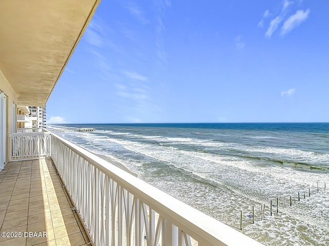 balcony with a water view and a beach view