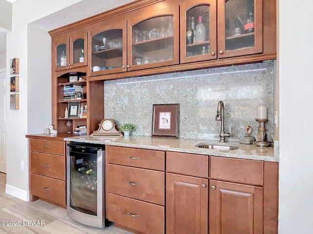 bar featuring baseboards, wet bar, a sink, decorative backsplash, and wine cooler