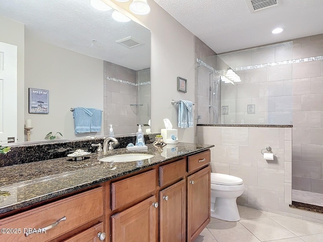 bathroom featuring tile patterned floors, visible vents, toilet, and a walk in shower