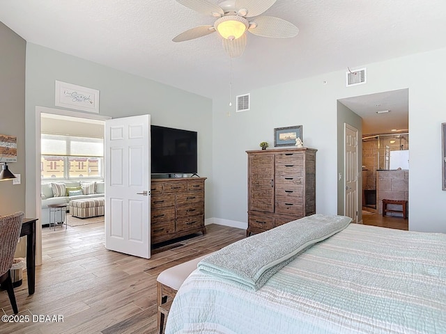 bedroom featuring ceiling fan, visible vents, a textured ceiling, and light wood-style flooring