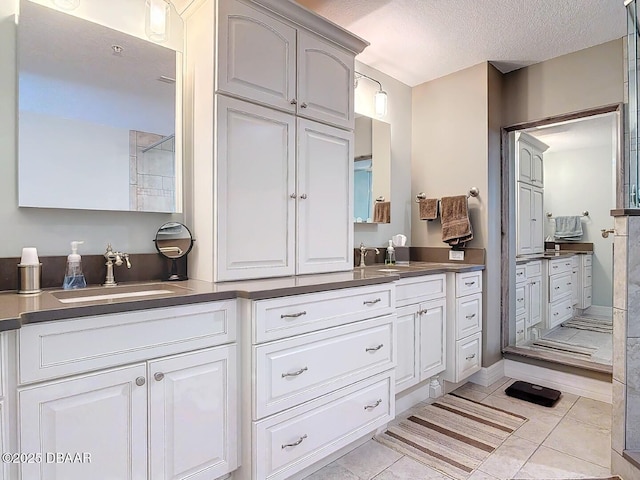 full bath featuring tile patterned floors, a textured ceiling, and vanity