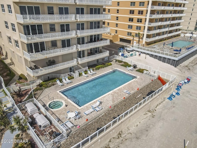 pool with a community hot tub, a patio area, and fence