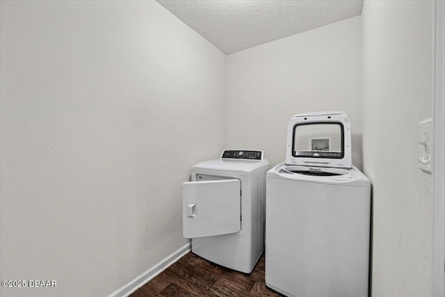 laundry area featuring dark wood-type flooring, washing machine and clothes dryer, and a textured ceiling