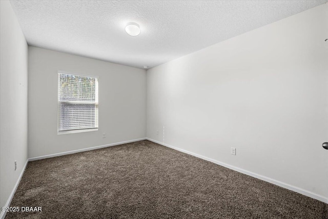 carpeted empty room featuring a textured ceiling