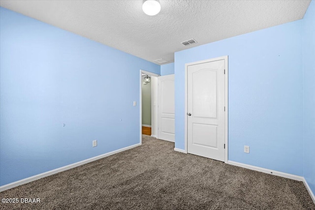 unfurnished bedroom with a textured ceiling and carpet