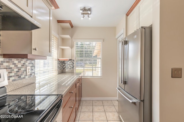 kitchen featuring appliances with stainless steel finishes, light tile patterned floors, backsplash, light stone counters, and light brown cabinets