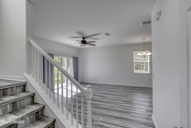 123 Langston Dr, Daytona Beach, FL 32124 - staircase featuring ceiling fan, wood finished floors, a chandelier, and baseboards