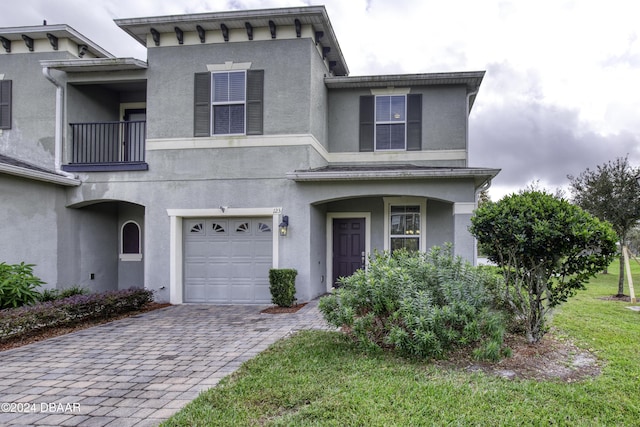 123 Langston Dr, Daytona Beach, FL 32124 - view of front of home featuring a garage, decorative driveway, a balcony, and stucco siding