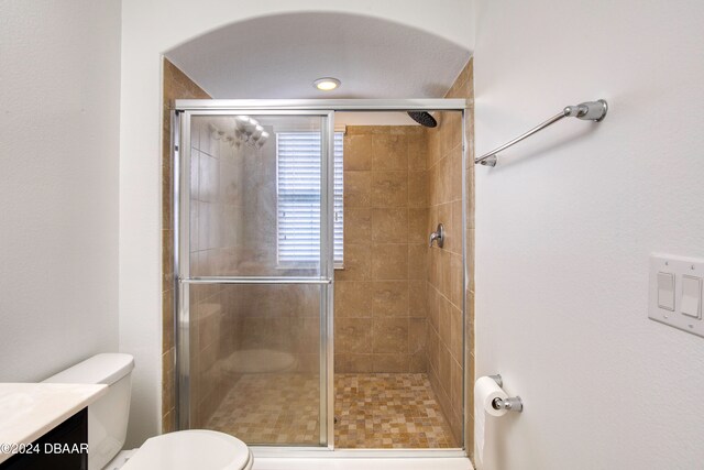 bathroom featuring toilet, vanity, and walk in shower