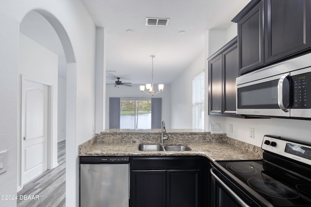 kitchen featuring ceiling fan with notable chandelier, light hardwood / wood-style flooring, sink, pendant lighting, and appliances with stainless steel finishes