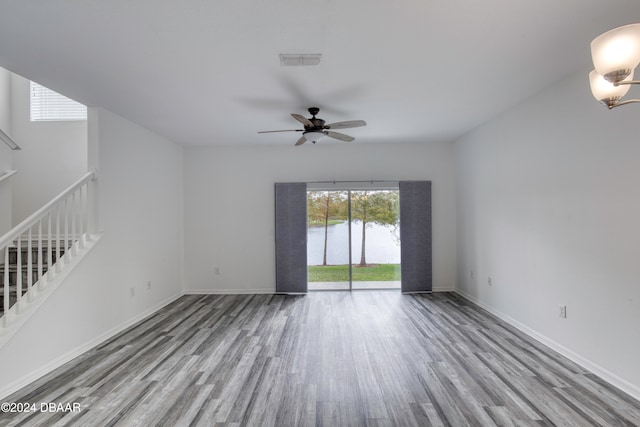 unfurnished living room with a water view, ceiling fan, and light hardwood / wood-style flooring