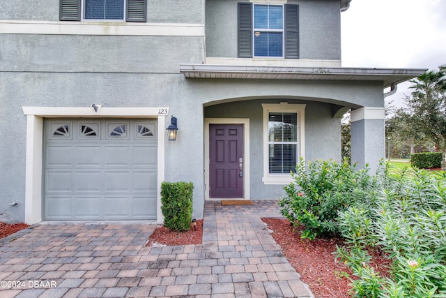 view of exterior entry with a garage