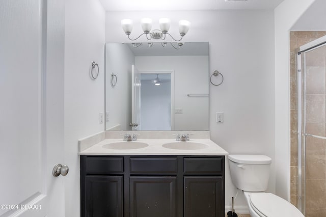 bathroom with a chandelier, vanity, toilet, and an enclosed shower