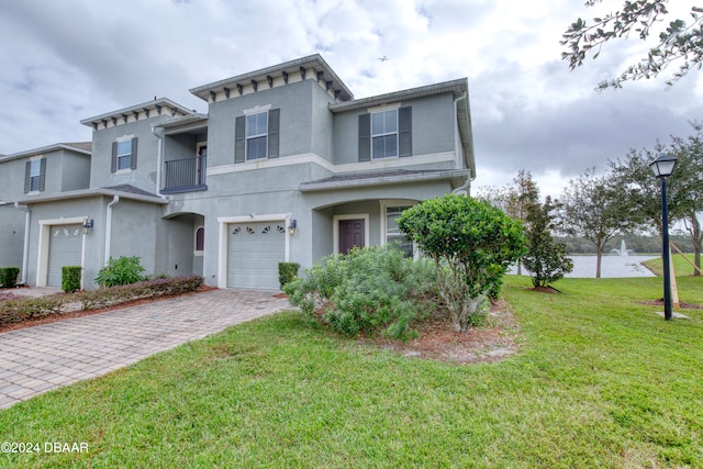 view of front of property with a front lawn, a garage, and a balcony