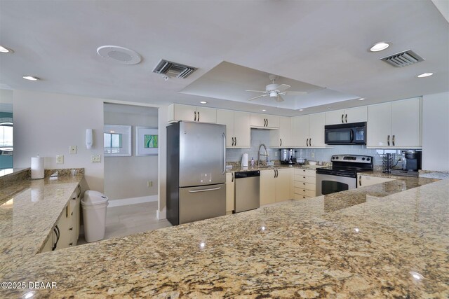 3855 S Atlantic Ave S Unit 1405, Daytona Beach, FL 32118 - kitchen with a tray ceiling, light stone countertops, stainless steel appliances, and visible vents