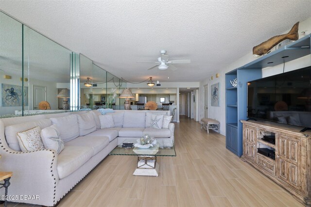 3855 S Atlantic Ave S Unit 1405, Daytona Beach, FL 32118 - living area featuring light wood-style floors, a ceiling fan, and a textured ceiling