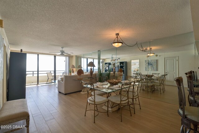 3855 S Atlantic Ave S Unit 1405, Daytona Beach, FL 32118 - dining room featuring a textured ceiling, light wood-style flooring, and a wall of windows