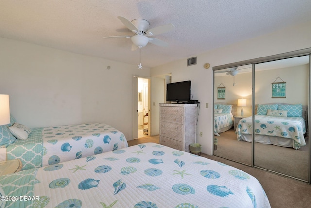 bedroom featuring carpet floors, a textured ceiling, a ceiling fan, visible vents, and a closet