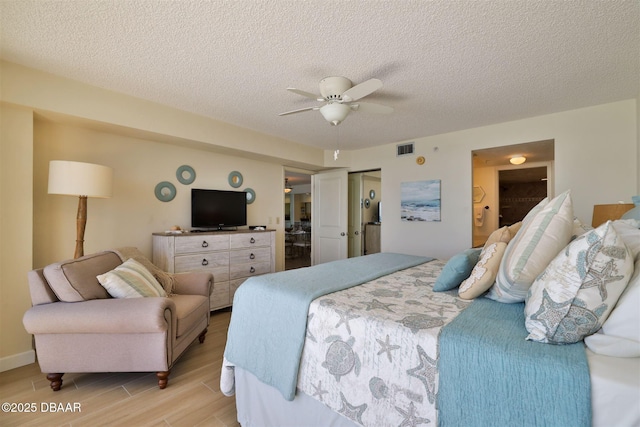 bedroom featuring visible vents, light wood-style floors, ensuite bathroom, a textured ceiling, and a ceiling fan