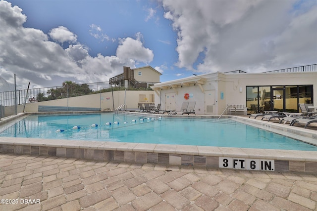 community pool featuring fence and a patio