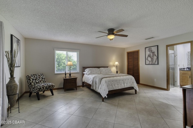29 Concord Dr, Ormond Beach, FL 32176 - bedroom featuring a textured ceiling, light tile patterned floors, a closet, a ceiling fan, and ensuite bath