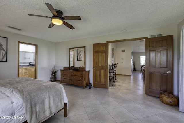 29 Concord Dr, Ormond Beach, FL 32176 - bedroom with a textured ceiling, light tile patterned floors, a ceiling fan, and ensuite bath