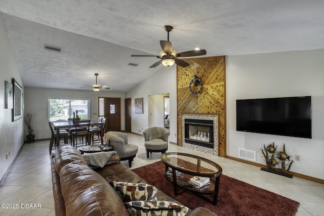 29 Concord Dr, Ormond Beach, FL 32176 - living room with light tile patterned floors, ceiling fan, lofted ceiling, and a tiled fireplace