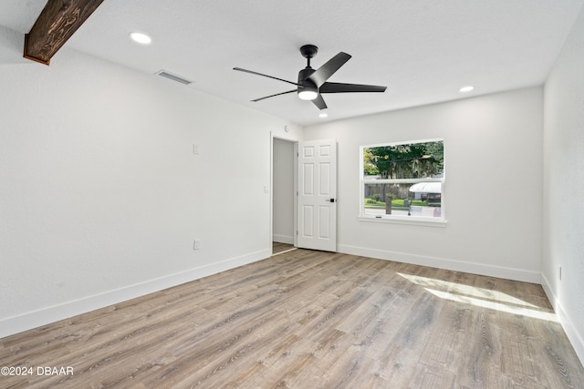 unfurnished room featuring beamed ceiling, ceiling fan, and light hardwood / wood-style floors