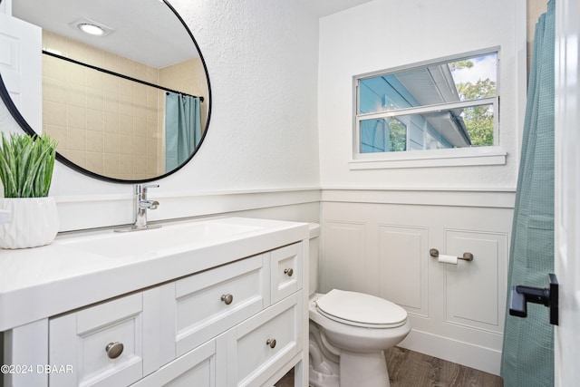 bathroom with toilet, vanity, wood-type flooring, and walk in shower