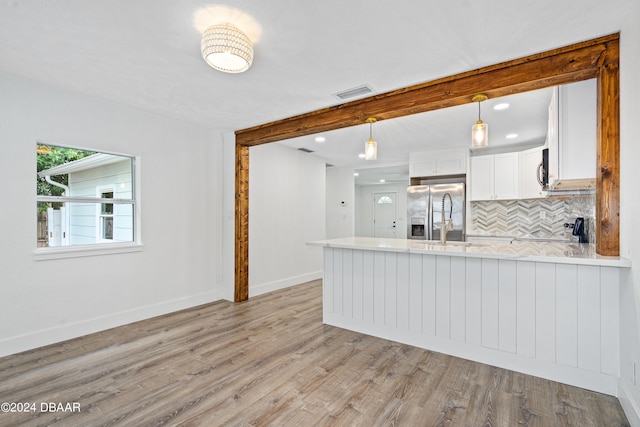 kitchen featuring kitchen peninsula, light hardwood / wood-style floors, white cabinetry, and appliances with stainless steel finishes