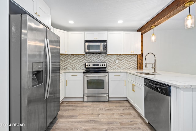 kitchen featuring stainless steel appliances, pendant lighting, sink, white cabinets, and kitchen peninsula