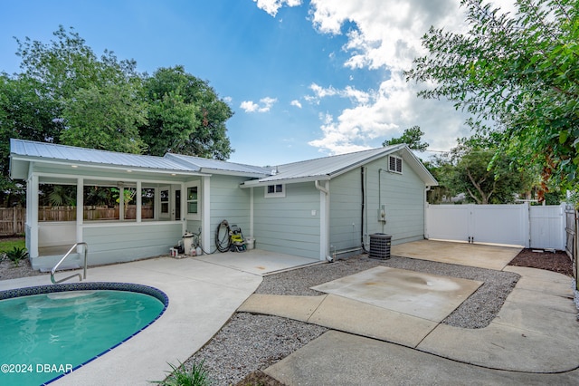 back of property with a fenced in pool and a patio