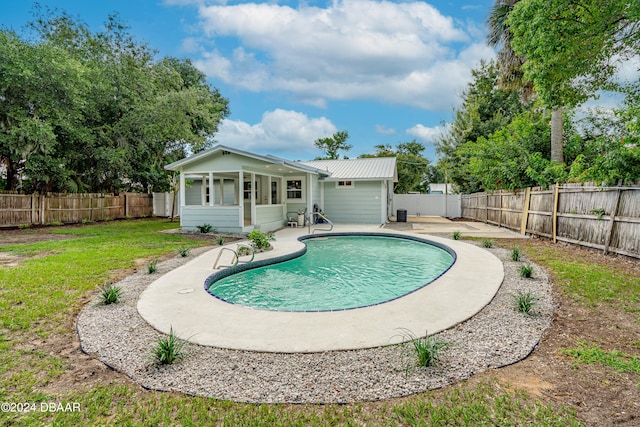 view of pool with a patio and a yard