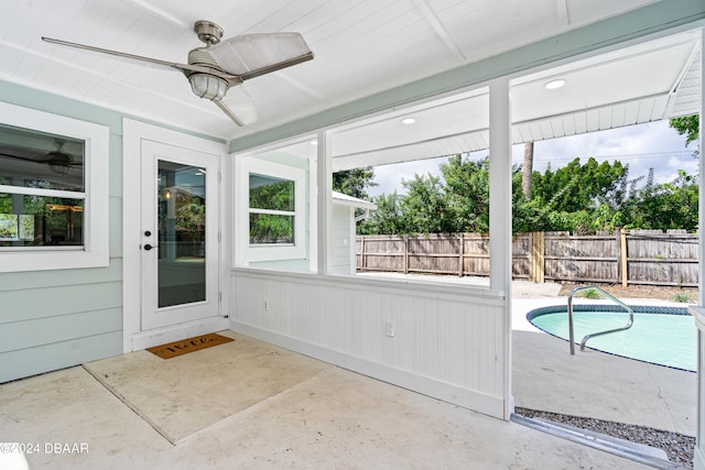 unfurnished sunroom with ceiling fan