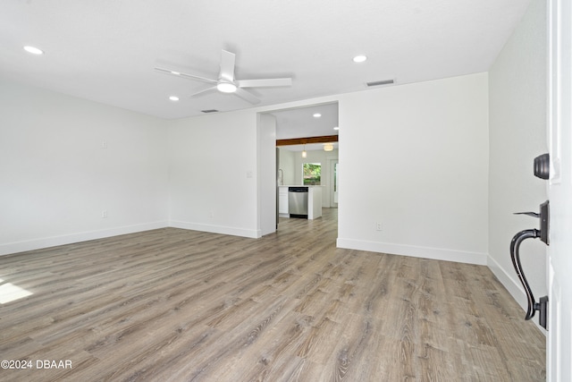 empty room with ceiling fan and light hardwood / wood-style flooring