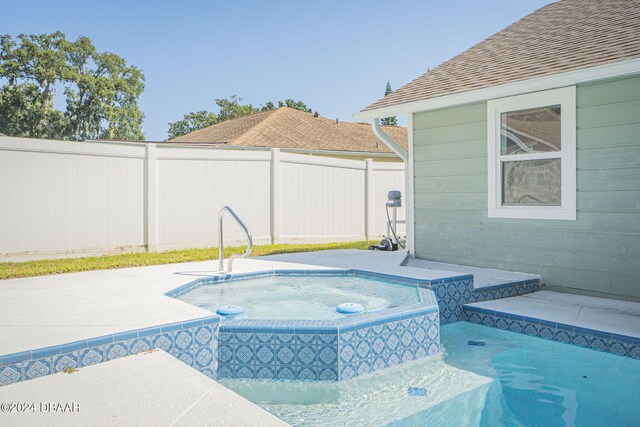 view of pool featuring a patio and a jacuzzi