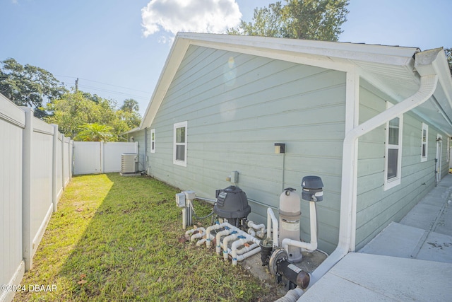 view of side of home with a lawn and cooling unit