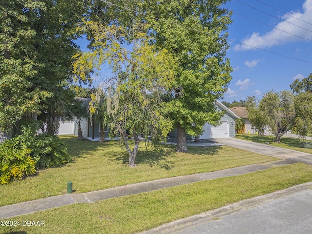 obstructed view of property with a garage and a front lawn