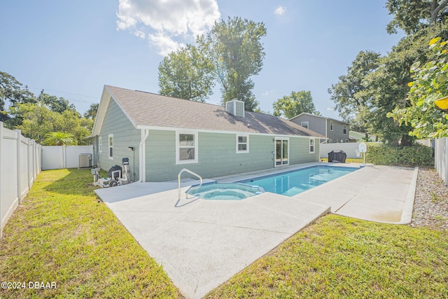 view of swimming pool featuring a patio, a lawn, and an in ground hot tub