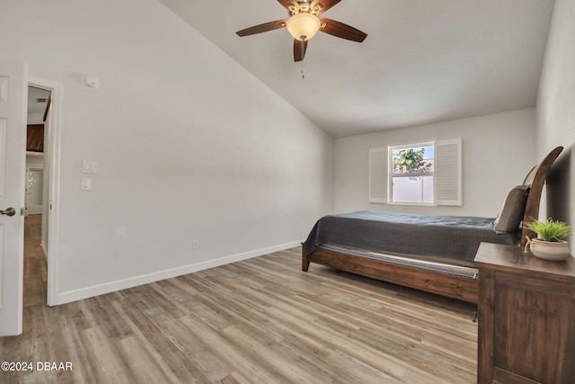 bedroom with ceiling fan, light hardwood / wood-style flooring, and vaulted ceiling