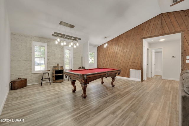 game room featuring pool table, light hardwood / wood-style floors, lofted ceiling, wood walls, and brick wall