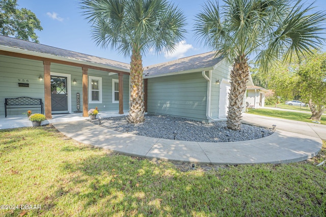 single story home with a porch, a front lawn, and a garage