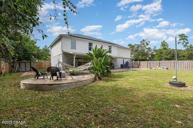 back of house with a yard, a shed, and a patio area