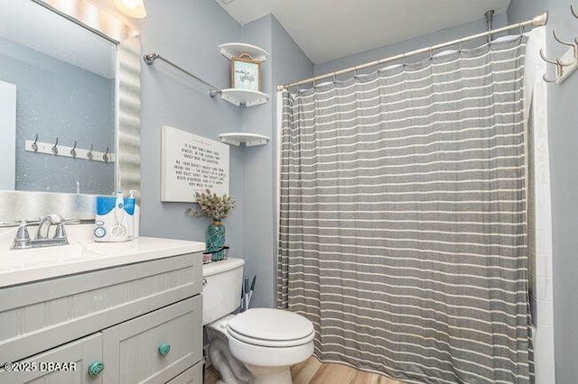 bathroom with curtained shower, toilet, vanity, and hardwood / wood-style flooring