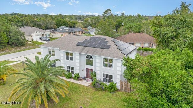 view of front of property with a front yard and solar panels