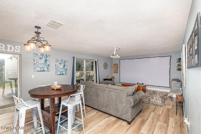 interior space featuring a chandelier, a textured ceiling, and light hardwood / wood-style floors