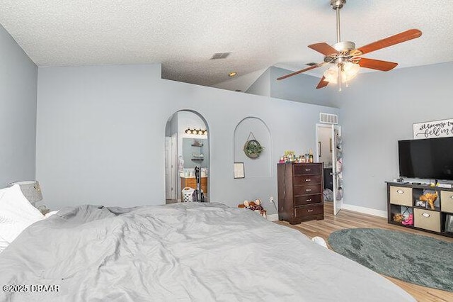 bedroom with a textured ceiling, light hardwood / wood-style flooring, ceiling fan, and lofted ceiling